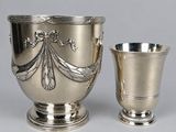 silver plated cup and saucer with ornate decoration on the sides