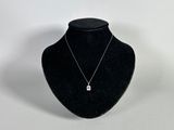 a black mannequin with a silver necklace on a white background