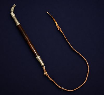 an old wooden stick with a metal handle on a dark background