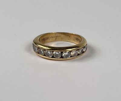 gros plan d'une bague en or avec des diamants sur une surface blanche