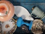 un chat assis dans un panier contenant de la vaisselle