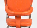 an orange chair that is sitting on a metal stand