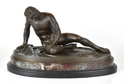 statue en bronze représentant un homme nu allongé sur un socle en marbre