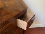a wooden desk with a drawer underneath it in a room