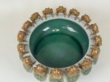 a green bowl with elephants in it on a white surface