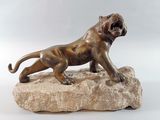 bronze statue of a lion on a rock on a white background