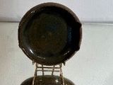 une assiette noire posée sur une chaise en métal
