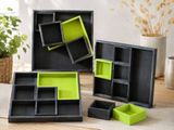Trois boîtes noires et vertes sont posées sur une table