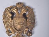 une image représentant une broche en or surmontée d'un oiseau