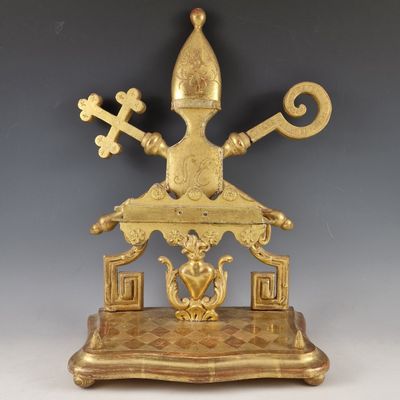 une statue en or représentant un homme tenant une croix et des clés