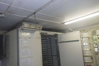 une photo d'un réfrigérateur dans une pièce comportant de nombreuses étagères