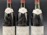 three bottles of wine are lined up on a table