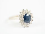un gros plan d'une bague en saphir et diamants sur fond blanc