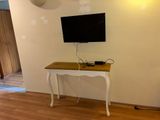 une petite table sur laquelle est posée une télévision, dans une pièce
