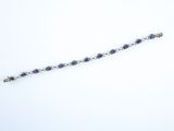 a close up of a bracelet with blue stones on a white surface