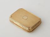 an image of a small gold plated box on a white surface