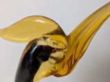 a glass sculpture of a bird on a white surface