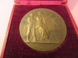 médaille d'or dans un écrin en velours rouge doublé de velours rouge