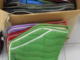 a box full of different colored saddle pads and a pair of scissors