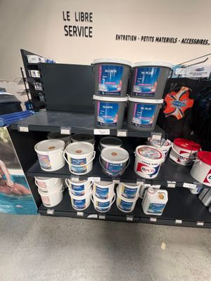 de nombreux seaux de peinture sur les rayons du magasin