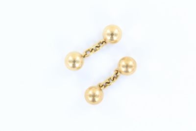 une paire de boucles d'oreilles en forme de boules dorées sur fond blanc
