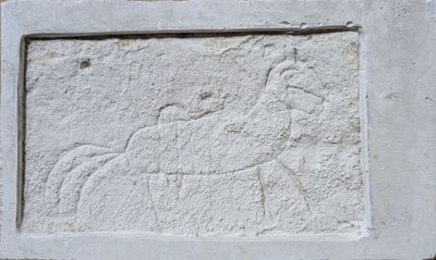une image représentant une plaque en pierre sur laquelle figurent un cheval et son cavalier