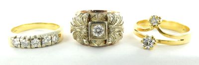 trois bagues en or et une bague en diamant posées sur un fond blanc