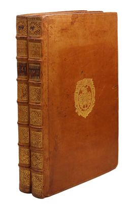 an old leather book with a gold emblem on the cover