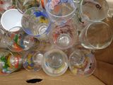 a cardboard box full of empty glasses and cups