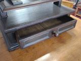 a wooden table with two drawers and a clock on it
