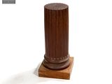 un socle en bois surmonté d'une colonne marron