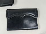 a black wallet sitting on a table next to a cell phone