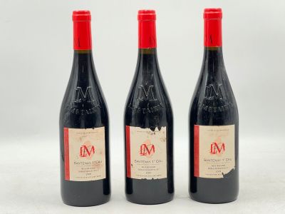 trois bouteilles de vin rouge posées l'une à côté de l'autre sur une surface blanche