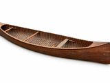 a wooden boat that is sitting on a white surface