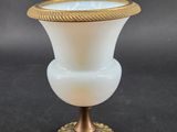 an image of a white vase with a gold rim on a black background