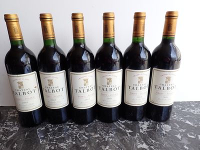 six bottles of red wine are lined up on a table