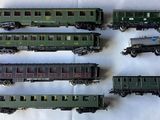 several toy trains are lined up in a row on a white surface