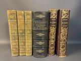 four books are lined up in a row on a gray surface