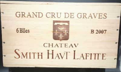une caisse en bois sur laquelle est accrochée une pancarte indiquant « Château Smith Hav Laffite »