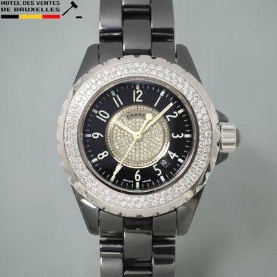 une montre noire dont le cadran est orné d'une lunette sertie de diamants