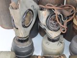 several old gas masks are stacked on top of each other