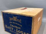 une vieille boîte en bois sur laquelle est collée une étiquette portant l'inscription « Château Haut Logat »