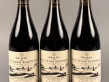 trois bouteilles de vin posées sur une table l'une à côté de l'autre