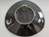 a black plate with a gold rim on a white table