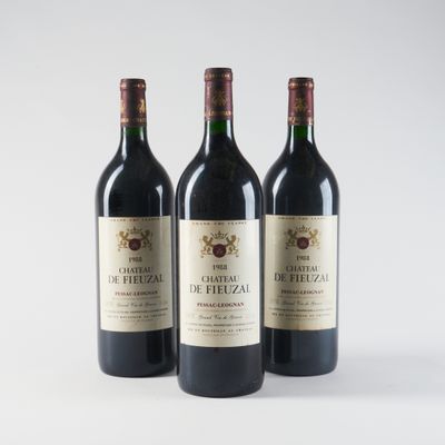 trois bouteilles de vin rouge posées l'une à côté de l'autre sur une surface blanche