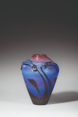 un vase bleu surmonté d'un couvercle rouge, posé sur une surface blanche