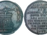 a close up of a coin with an image of a bell on it