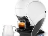a white coffee machine with a cup of coffee next to it