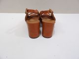 brown leather sandals with buckles on the toes on a white surface