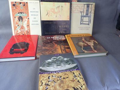 Plusieurs livres sont posés sur un lit recouvert d'une couette bleue